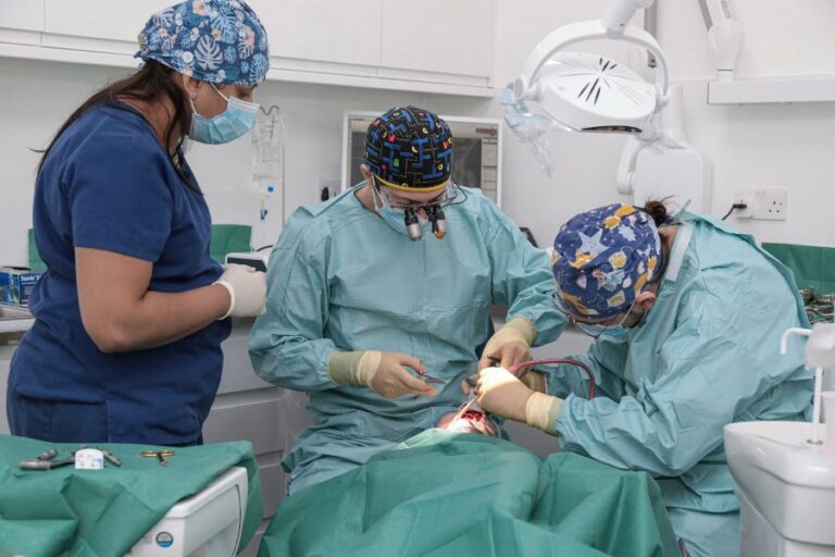 Dr Eric Battista and his assistant during surgery for immediate implants